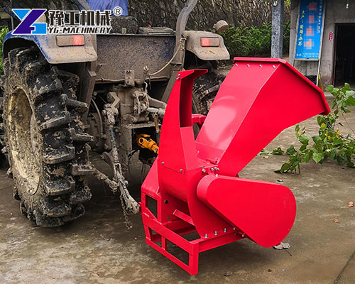 Farm tractor with attached wood shredder