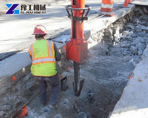 Excavator rock splitter working at urban construction site