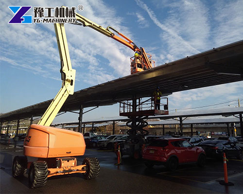 Knuckle boom lift reaching over roof edge