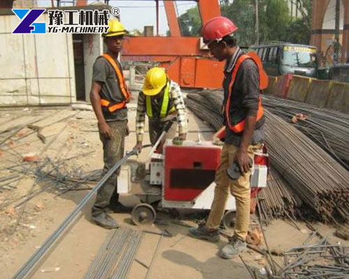 Worker using hydraulic rebar cutter for building project