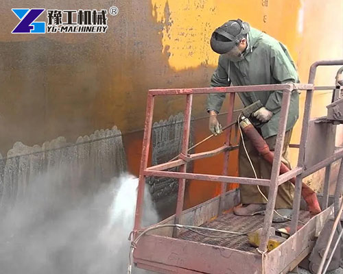 Worker using wet abrasive blasting machine