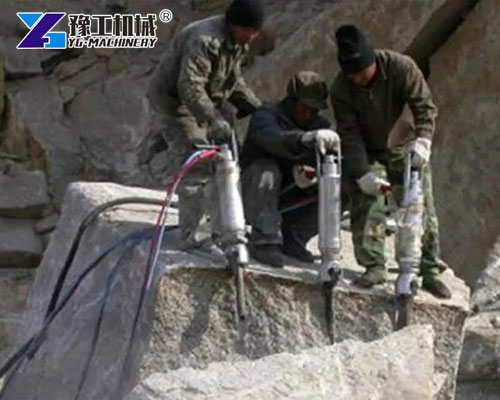 Quarry workers using electric hydraulic rock splitter