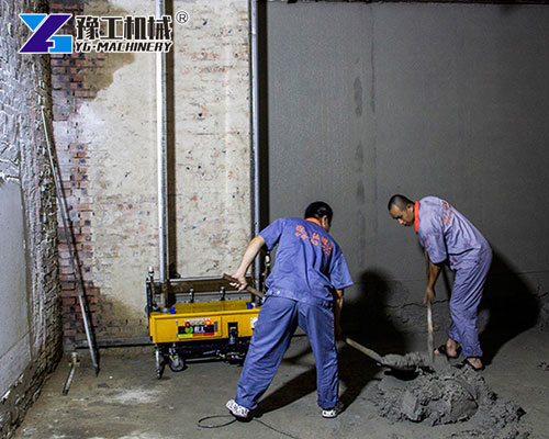 Worker operating automatic wall plastering machine