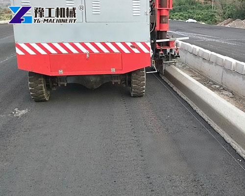 Concrete curb machine shaping smooth roadside curbs