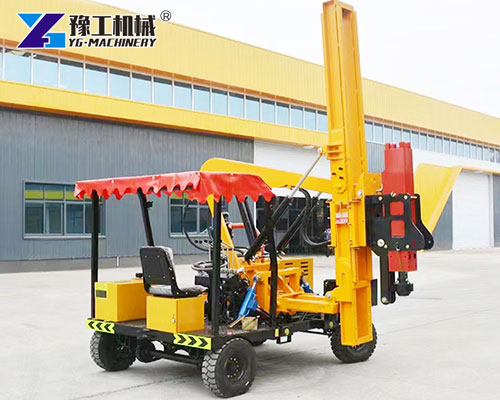 Highway guardrail pile driver on road project site